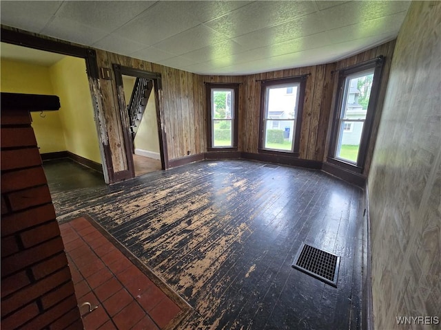 213 Highland Ave, Shelby, NY 14103 - unfurnished living room featuring stairway, wood-type flooring, and wood walls