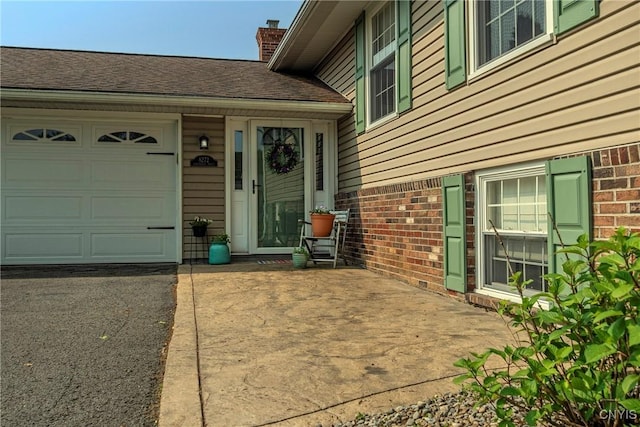 8272 Northgate Dr, Rome-Outside, NY 13440 - view of exterior entry with a garage, brick siding, a chimney, and driveway