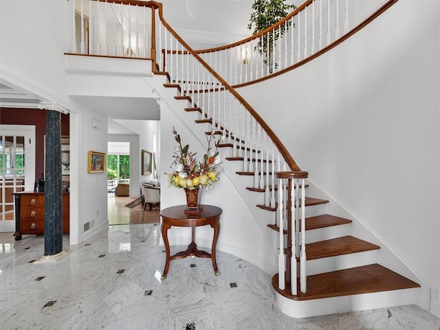 1010 Plank Rd, Penfield, NY 14580 - stairs featuring a high ceiling, decorative columns, and marble tiled floors