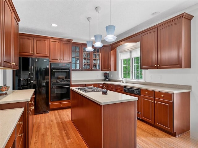 1010 Plank Rd, Penfield, NY 14580 - kitchen with black appliances, light wood finished floors, glass insert cabinets, decorative light fixtures, and light countertops
