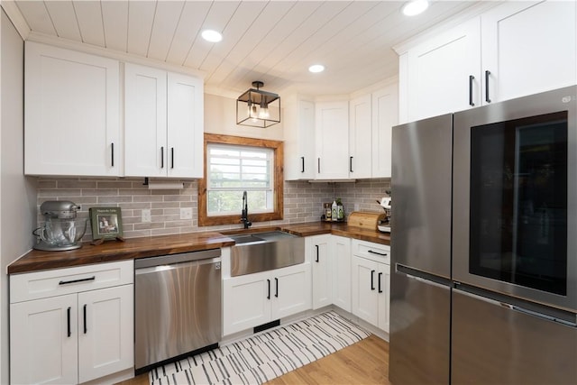 7046 Safford Ave Unit 12, Castile, NY 14530 - kitchen featuring wood counters, appliances with stainless steel finishes, recessed lighting, white cabinetry, and backsplash