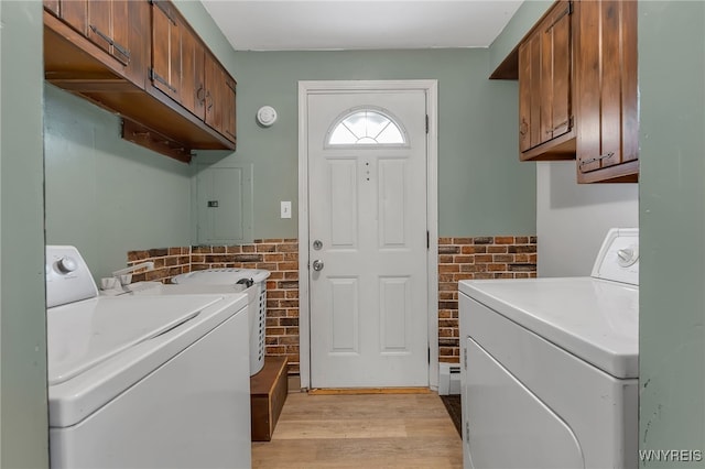 4306 Shimerville Rd, Clarence, NY 14031 - washroom featuring washing machine and dryer, electric panel, cabinet space, light wood-style flooring, and brick wall