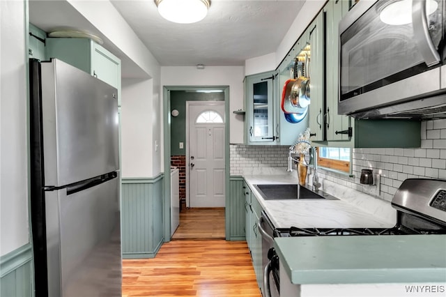 4306 Shimerville Rd, Clarence, NY 14031 - kitchen featuring stainless steel appliances, green cabinetry, light wood-type flooring, and a wainscoted wall
