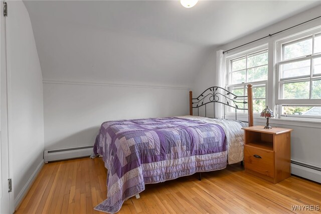 4306 Shimerville Rd, Clarence, NY 14031 - bedroom with a baseboard heating unit, vaulted ceiling, and light wood-type flooring