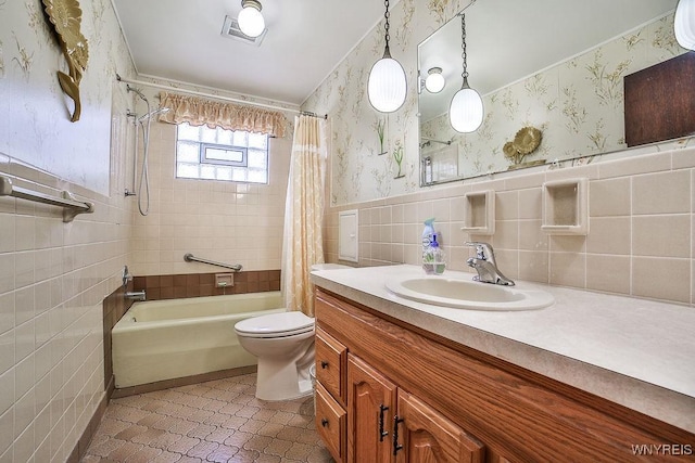 48 Kibler Dr, Lancaster, NY 14043 - full bath with tile walls, wallpapered walls, shower / bath combination with curtain, vanity, and a wainscoted wall