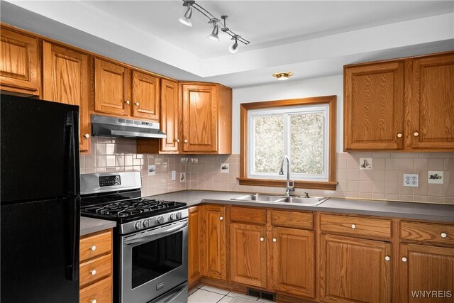482 Loretta St, Tonawanda-Town, NY 14223 - kitchen featuring freestanding refrigerator, stainless steel range with gas stovetop, under cabinet range hood, and brown cabinets