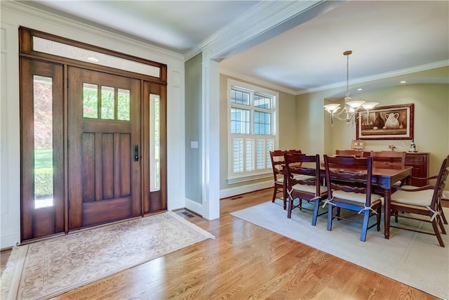 393 Mendon Center Rd, Mendon, NY 14472 - foyer featuring plenty of natural light, a chandelier, ornamental molding, and light wood-type flooring