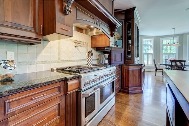 393 Mendon Center Rd, Mendon, NY 14472 - kitchen featuring double oven range, light wood-type flooring, decorative backsplash, wall chimney exhaust hood, and glass insert cabinets