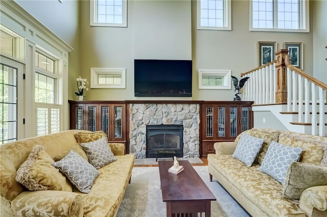 393 Mendon Center Rd, Mendon, NY 14472 - living room featuring a towering ceiling, a stone fireplace, and stairs