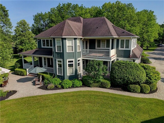 393 Mendon Center Rd, Mendon, NY 14472 - view of front of house featuring a front yard, a shingled roof, covered porch, and a balcony