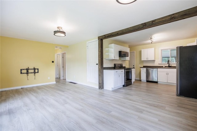 88 Rouge Rd, Henrietta, NY 14623 - kitchen featuring appliances with stainless steel finishes, dark countertops, open floor plan, decorative backsplash, and white cabinetry