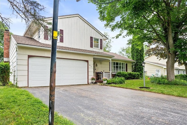 217 Red Lion Rd, Henrietta, NY 14467 - view of front of house featuring driveway, a garage, a front yard, a chimney, and board and batten siding