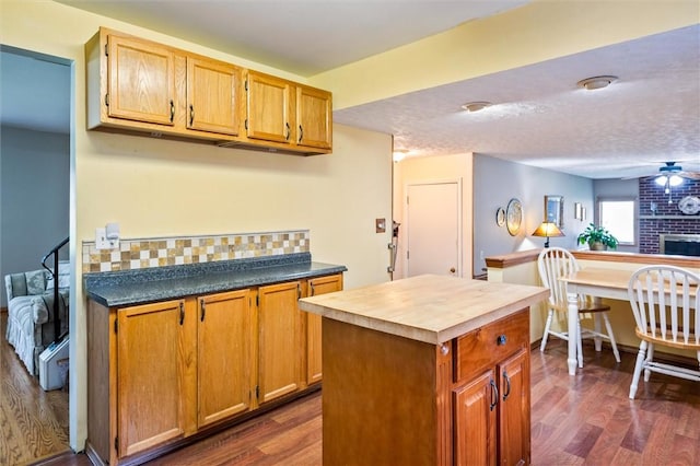 217 Red Lion Rd, Henrietta, NY 14467 - kitchen with dark wood-style floors, decorative backsplash, a kitchen island, and a ceiling fan