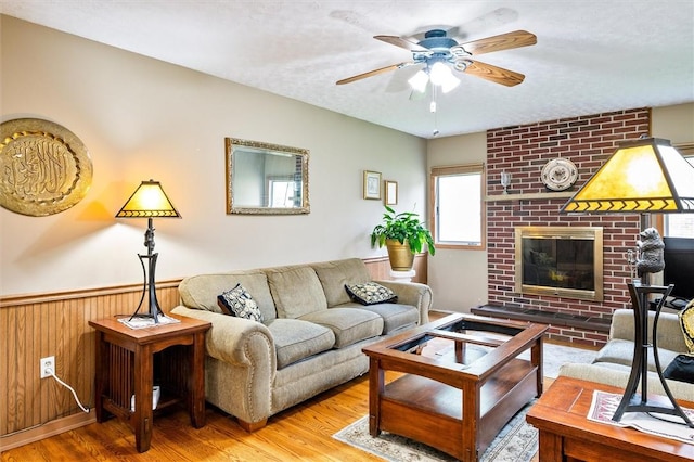 217 Red Lion Rd, Henrietta, NY 14467 - living area with wood finished floors, ceiling fan, a fireplace, a wainscoted wall, and wooden walls