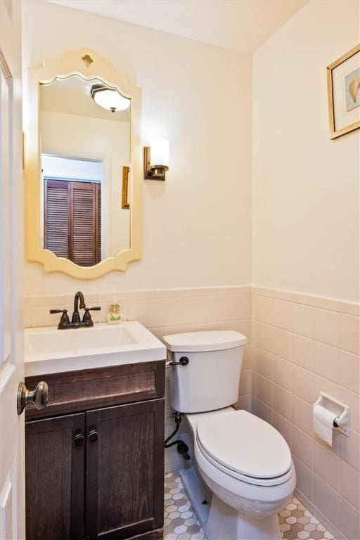 217 Red Lion Rd, Henrietta, NY 14467 - half bathroom with vanity, tile walls, and a wainscoted wall