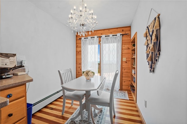 474 Thorpe Rd, Sidney, NY 13838 - dining room featuring a baseboard heating unit, light wood-style floors, a chandelier, and wood walls