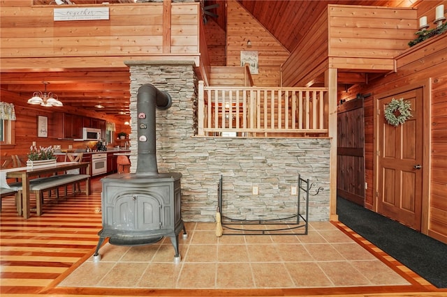 474 Thorpe Rd, Sidney, NY 13838 - tiled living area with wood walls, a wood stove, high vaulted ceiling, and wood ceiling
