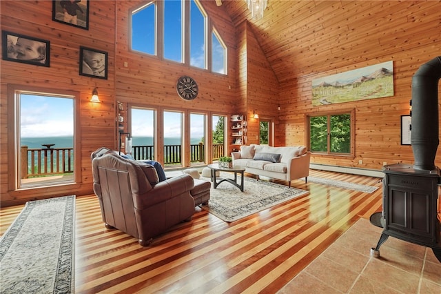 474 Thorpe Rd, Sidney, NY 13838 - living area with high vaulted ceiling, a wood stove, wood walls, and light wood-style floors