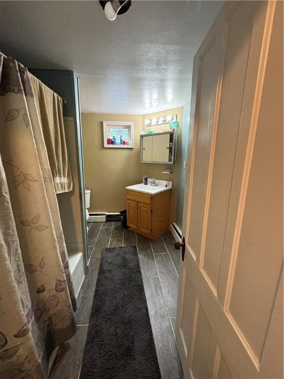 839 State Highway 7, Unadilla, NY 13849 - full bathroom with vanity, a baseboard radiator, and wood finished floors