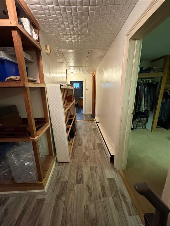 839 State Highway 7, Unadilla, NY 13849 - hall featuring baseboard heating, attic access, and wood finished floors