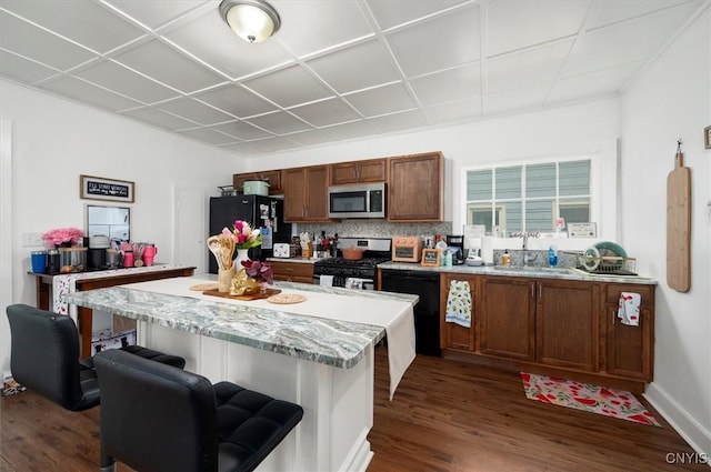 16 Meadow St, Kirkland, NY 13323 - kitchen with black appliances, dark wood finished floors, a kitchen bar, and brown cabinets