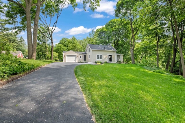 38 Richs Dugway Rd, Brighton, NY 14625 - view of front of home with asphalt driveway, an attached garage, a front lawn, and view of wooded area