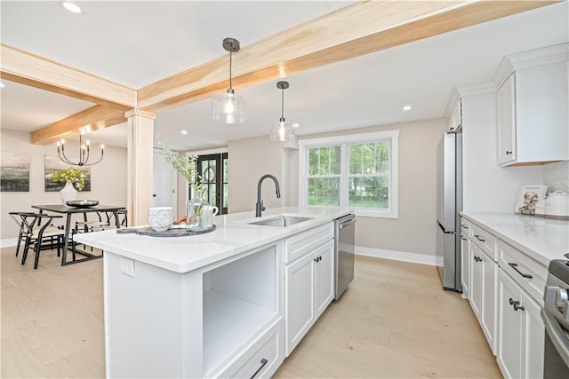 38 Richs Dugway Rd, Brighton, NY 14625 - kitchen featuring beamed ceiling, stainless steel appliances, white cabinets, a center island with sink, and light countertops