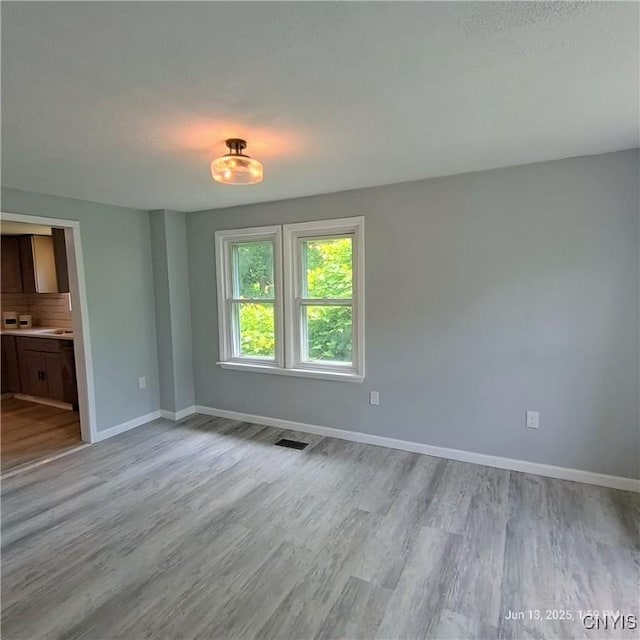 504 Breman Ave, Salina, NY 13211 - unfurnished living room with light wood-style flooring and baseboards