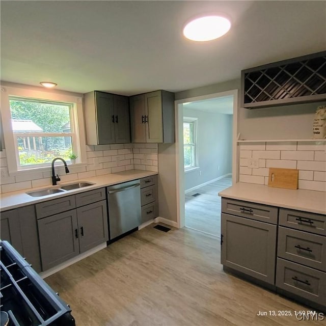 504 Breman Ave, Salina, NY 13211 - kitchen featuring stainless steel dishwasher, gray cabinetry, light wood-type flooring, and backsplash