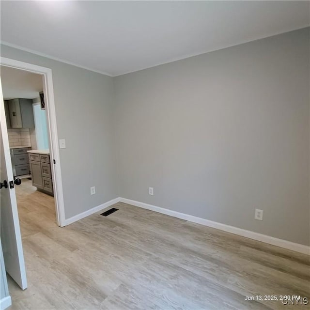 504 Breman Ave, Salina, NY 13211 - spare room featuring light wood finished floors and ornamental molding