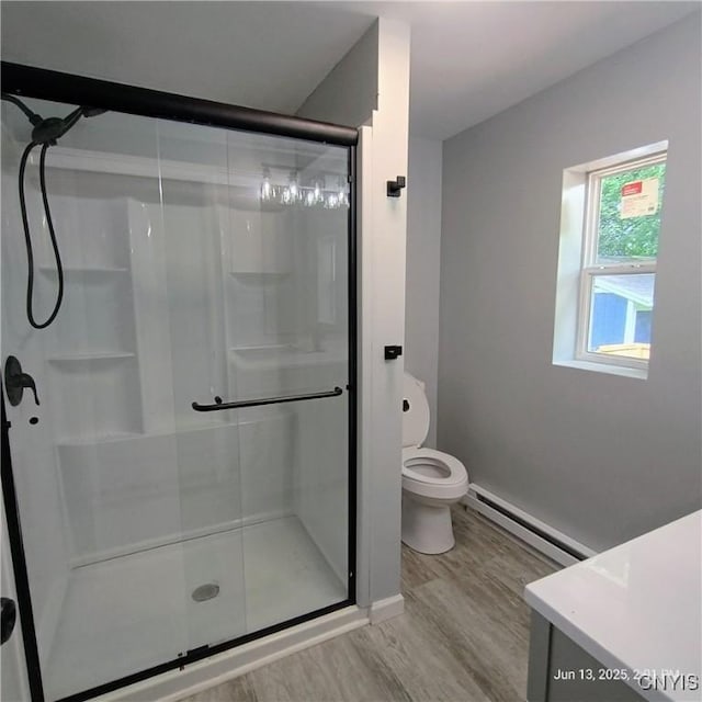 504 Breman Ave, Salina, NY 13211 - bathroom with baseboard heating, a shower stall, wood finished floors, and vanity