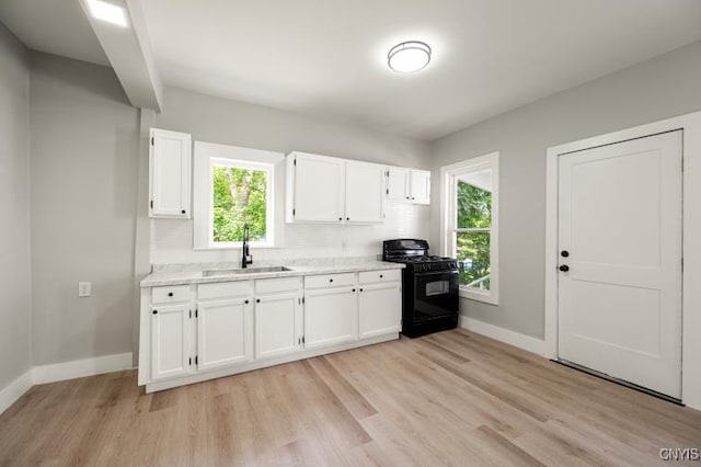 321 Pleasant Ave, Oneida-Inside, NY 13421 - kitchen with gas stove, white cabinets, light wood-type flooring, and light stone countertops