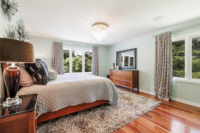 5 Elmwood Hill Ln, Brighton, NY 14610 - bedroom with wood finished floors and a chandelier