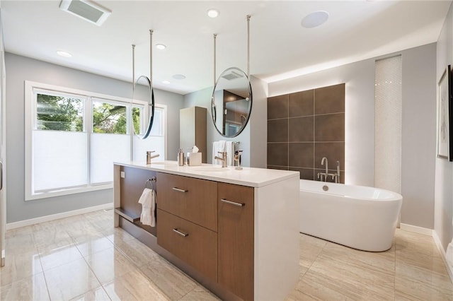 5 Elmwood Hill Ln, Brighton, NY 14610 - full bath featuring a freestanding tub, double vanity, tile patterned floors, and recessed lighting