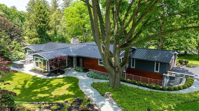 5 Elmwood Hill Ln, Brighton, NY 14610 - view of front facade with a standing seam roof, a chimney, a metal roof, and a front yard