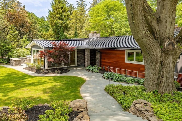 5 Elmwood Hill Ln, Brighton, NY 14610 - view of front of home with a standing seam roof, a chimney, a metal roof, and a front lawn