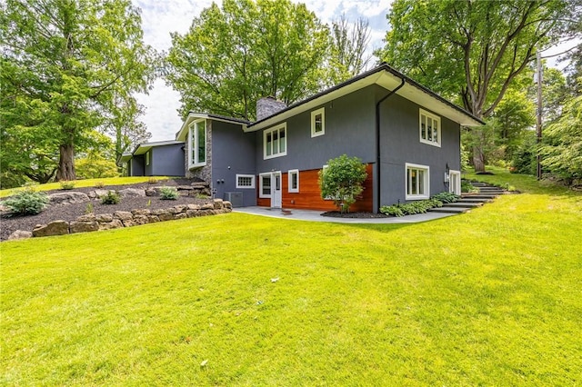 5 Elmwood Hill Ln, Brighton, NY 14610 - rear view of house featuring a chimney, stucco siding, a lawn, and a patio area