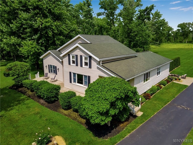 2391 Hess Rd, Newfane, NY 14008 - view of home's exterior featuring a shingled roof, a patio, and a yard