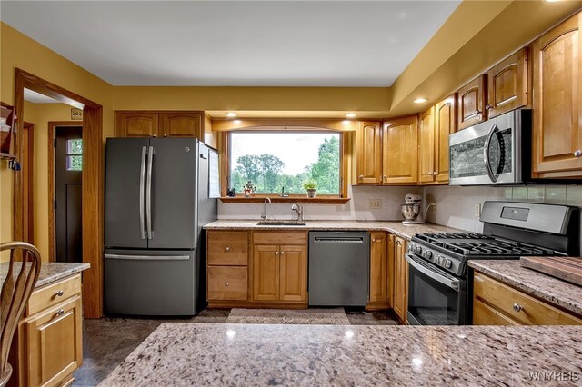 2391 Hess Rd, Newfane, NY 14008 - kitchen featuring stainless steel appliances, light stone countertops, healthy amount of natural light, and brown cabinets