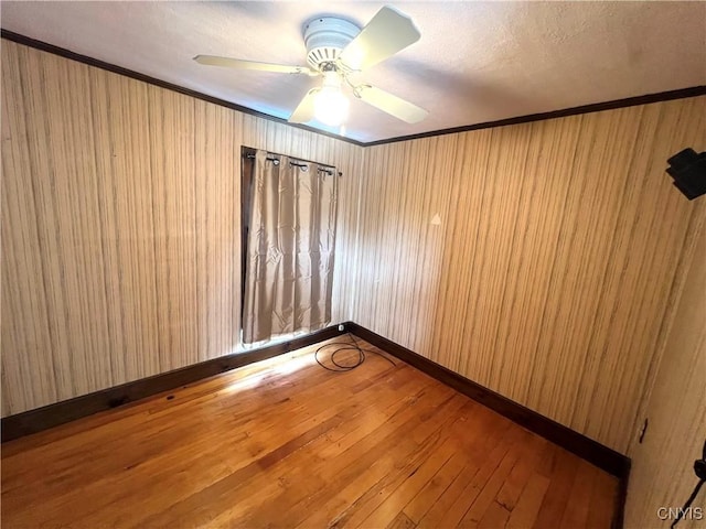 41 Evergreen St, Cortland, NY 13045 - unfurnished room featuring crown molding, wood-type flooring, ceiling fan, and wooden walls