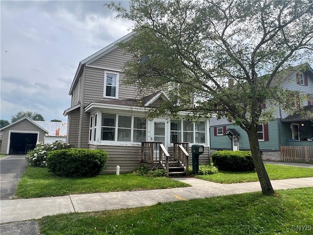41 Evergreen St, Cortland, NY 13045 - view of front facade with an outbuilding, a front yard, a detached garage, and driveway