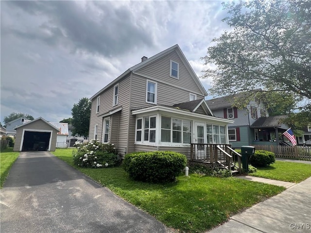 41 Evergreen St, Cortland, NY 13045 - view of front of house with an outdoor structure, asphalt driveway, a detached garage, and a chimney
