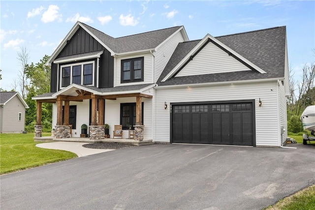 591 Whistlers Cove Ln, Greece, NY 14612 - view of front facade featuring covered porch, a garage, board and batten siding, driveway, and a shingled roof