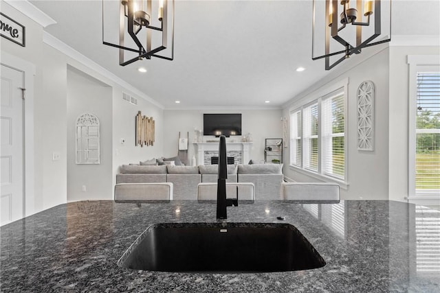 591 Whistlers Cove Ln, Greece, NY 14612 - kitchen with a chandelier, a fireplace, ornamental molding, dark stone counters, and recessed lighting