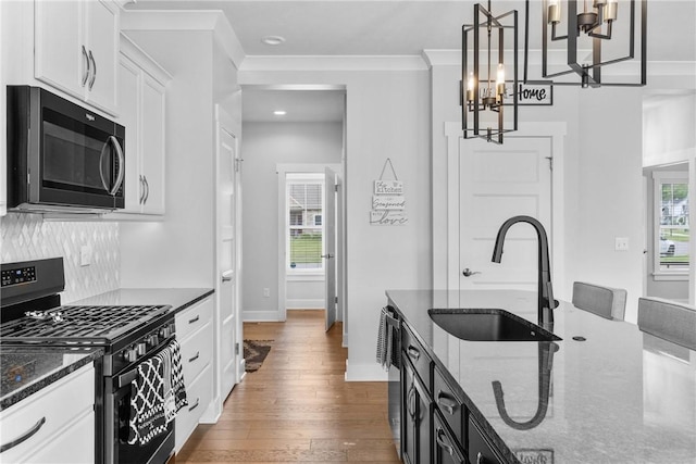 591 Whistlers Cove Ln, Greece, NY 14612 - kitchen featuring black gas stove, a chandelier, dark wood-style flooring, dark stone countertops, and white cabinets