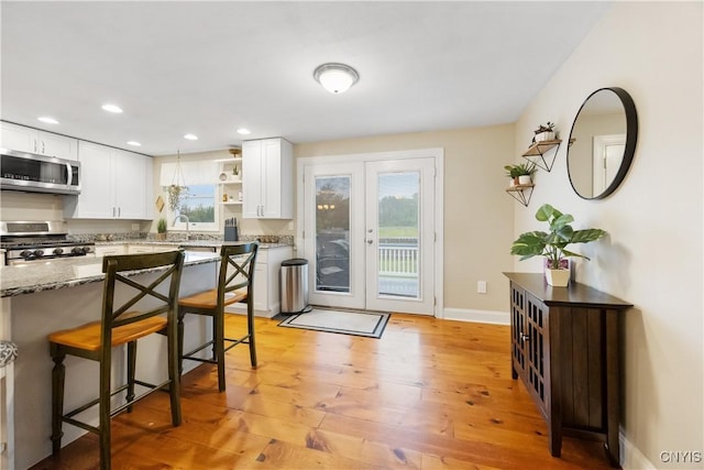 8185 Mantova Dr, Clay, NY 13041 - kitchen with appliances with stainless steel finishes, open shelves, light stone counters, white cabinetry, and recessed lighting