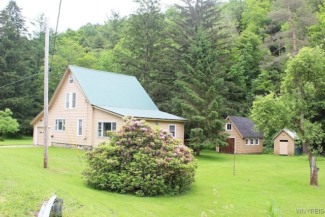 5046 Whig St, Little Valley, NY 14779 - view of home's exterior featuring a storage shed, a lawn, a garage, and a metal roof
