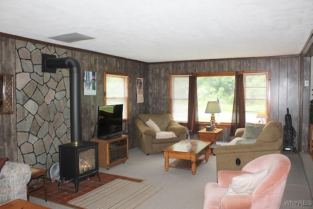 5046 Whig St, Little Valley, NY 14779 - carpeted living room featuring a wood stove, wooden walls, and crown molding