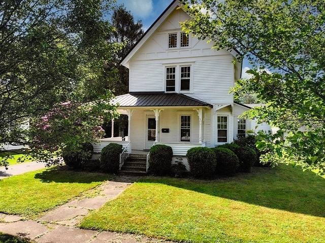 306 Broad St, Port Allegany Boro, PA 16743 - view of front facade with covered porch, a front yard, a metal roof, and a standing seam roof