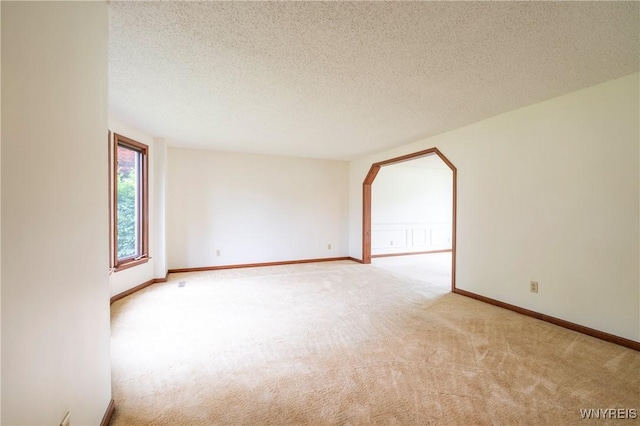 64 Bywater Dr, Amherst, NY 14068 - unfurnished room featuring light colored carpet, a textured ceiling, and arched walkways